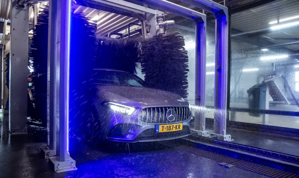 Een auto ondergaat een wasbeurt in een geautomatiseerde wasstraat.