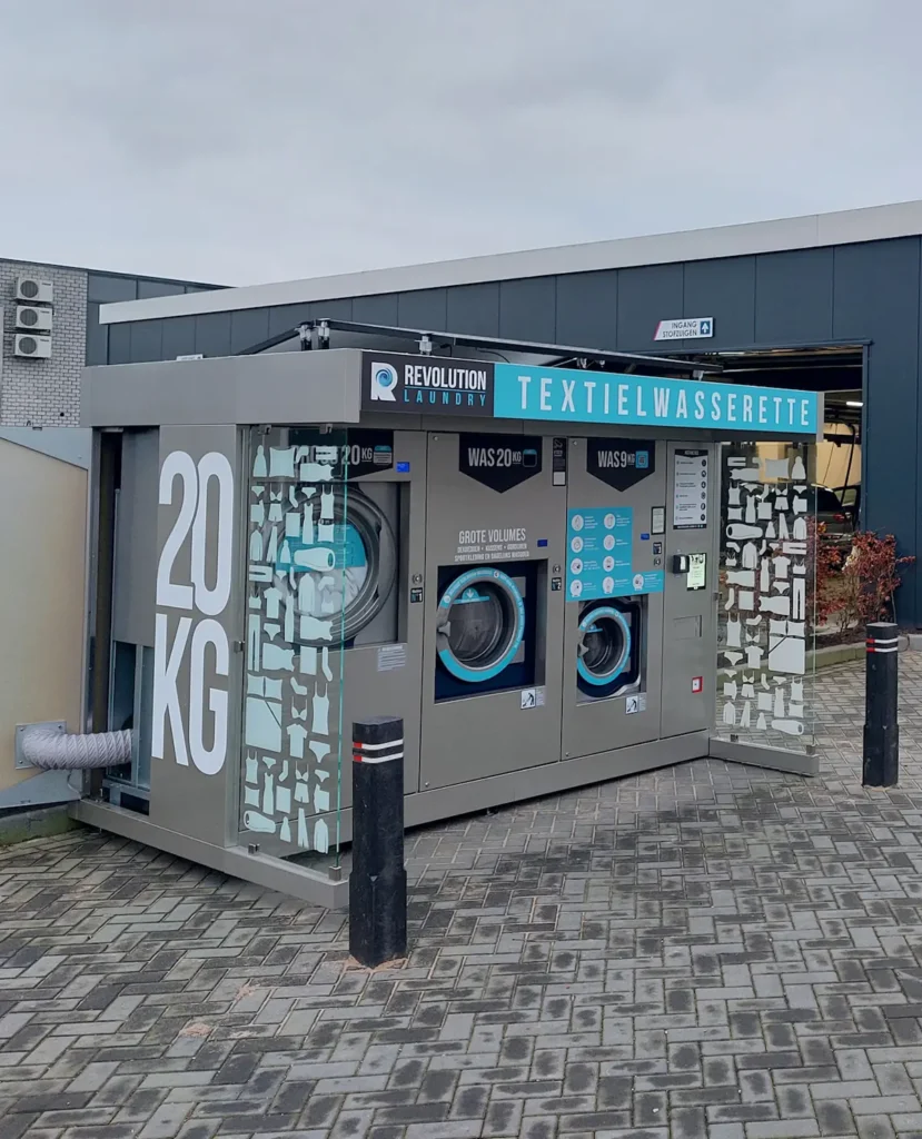 Een outdoor textielwasserette met meerdere wasmachines naast een gebouw.
